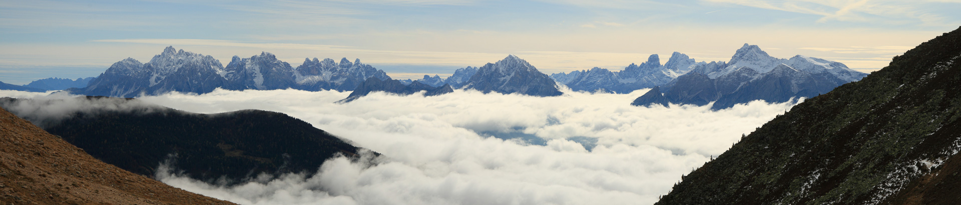 Über den Wolken erheben sich die Dolomiten.