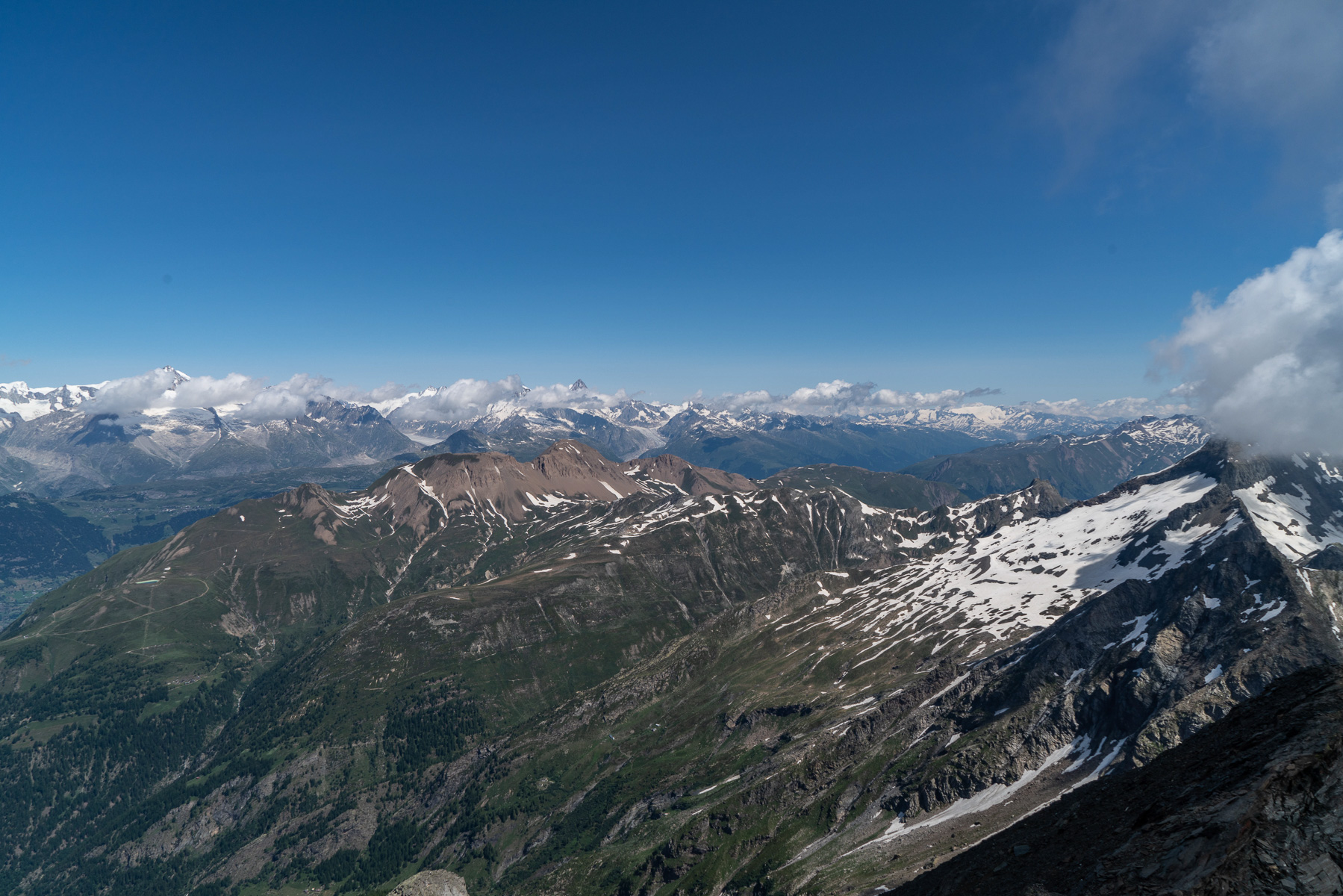 Wolkenverhangener Blick in die Berner Alpen - davor in rot das Bättlihorn